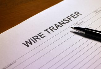 A pen sitting on top of a blank wire transfer document