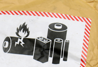 Close-up of a battery corrosion warning graphic on the side of a shipping envelope. 