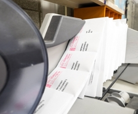 A mail processor sorting through closed mail envelopes.
