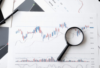 A magnifying glass sitting on top of a document containing prediction graphs. 