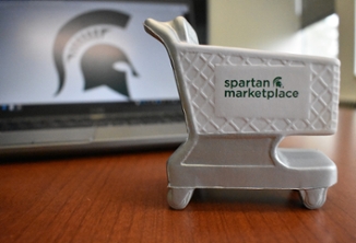 A picture of a toy, white shopping cart with the Spartan marketplace logo on the side. 